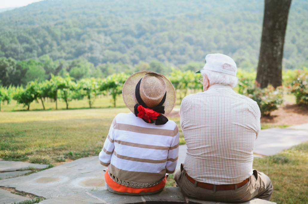 An elderly couple is enjoying the beautiful scenery while on vacation.